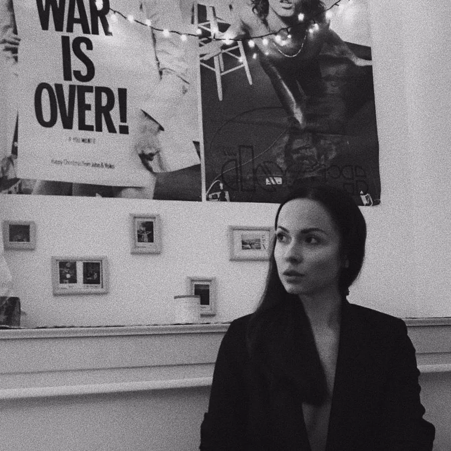 Nataliia Lashkevych in einer Ausstellung, im Hintergrund ein Plakat „War is over!“